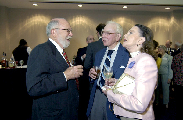 Speaker Jim Wright talking with two Friends of the TCU Library at an event.
