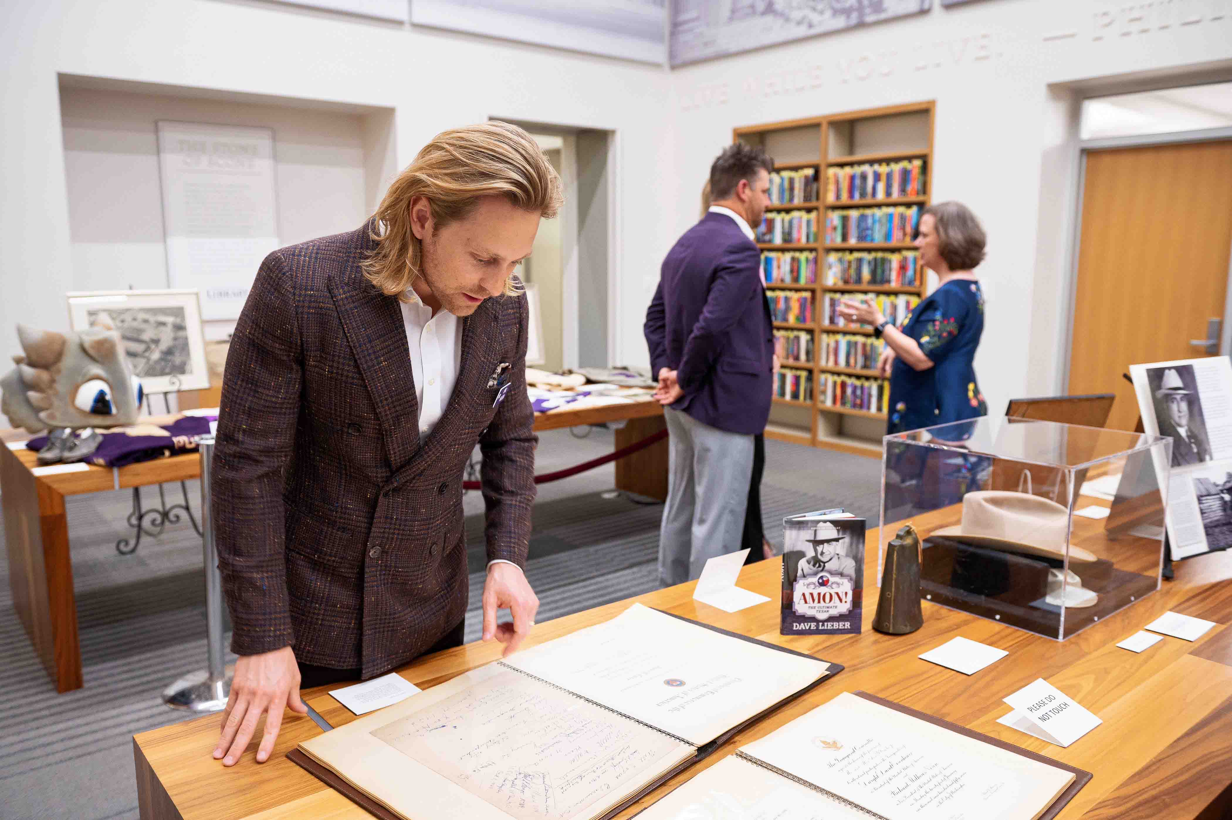 Eric Nelsen looking at Amon G. Carter's guestbook
