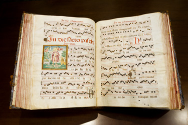 An open 17th century book, showing a music score and an illustration