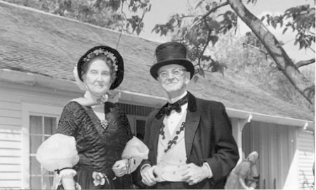 Joseph Lynn and Sallie Chism Clark in front of Huntsville, Texas, home of Gen and Mrs Sam Houston, dressed in early Texan costume